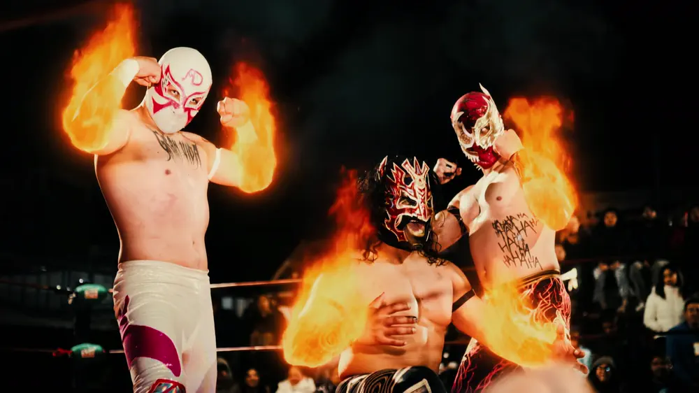 Luchadores lanzando fuego dentro del ring